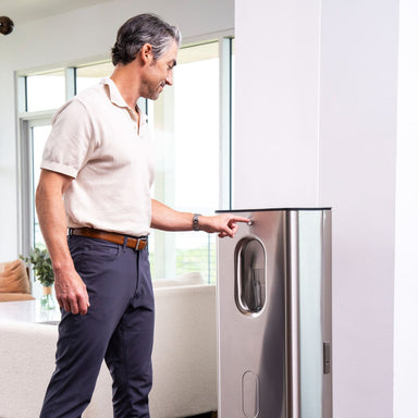 Man pressing button on Kara Pure 2 water generator