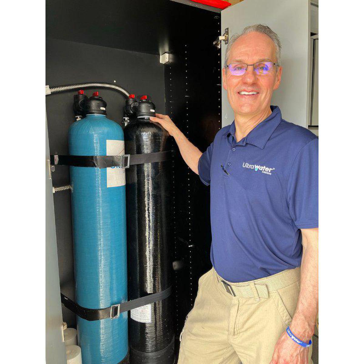 UltraWater UltraHome Premium + Salt-Free Softener Combo man holding the system